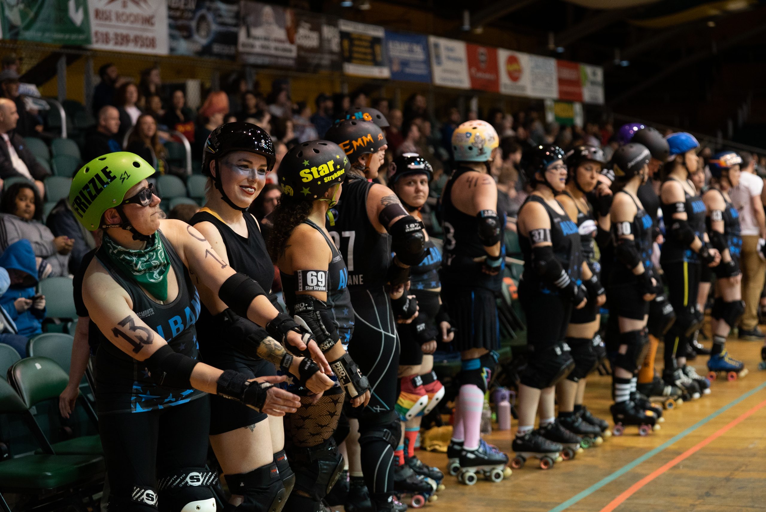 A group of roller derby skaters, standing in a line